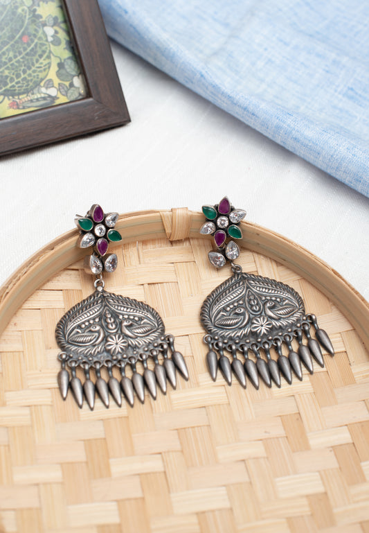 a close up of a pair of earrings on a bamboo tray